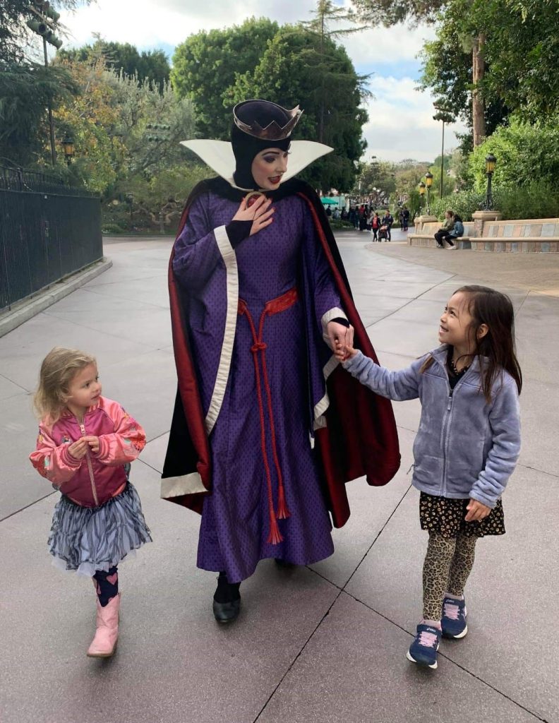 Photo of the Evil Queen hanging out with a couple of girls at Disneyland.